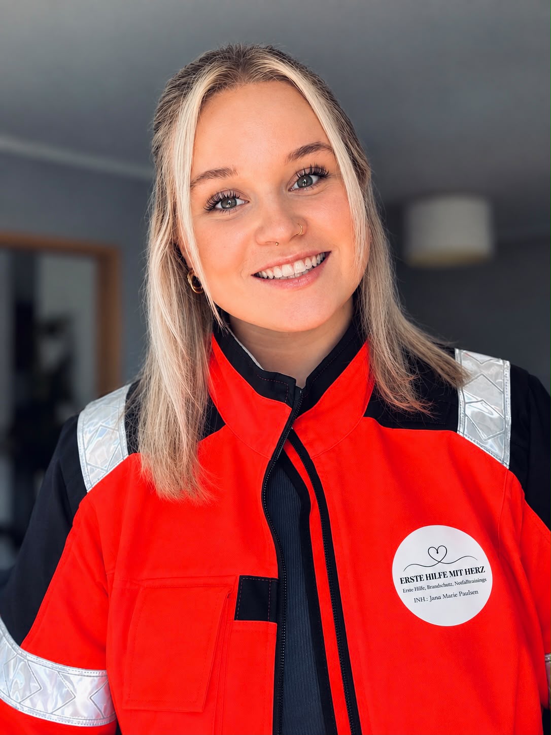 Jana Marie Paulsen in roter Einsatzkleidung mit dem Logo von Erste Hilfe mit Herz